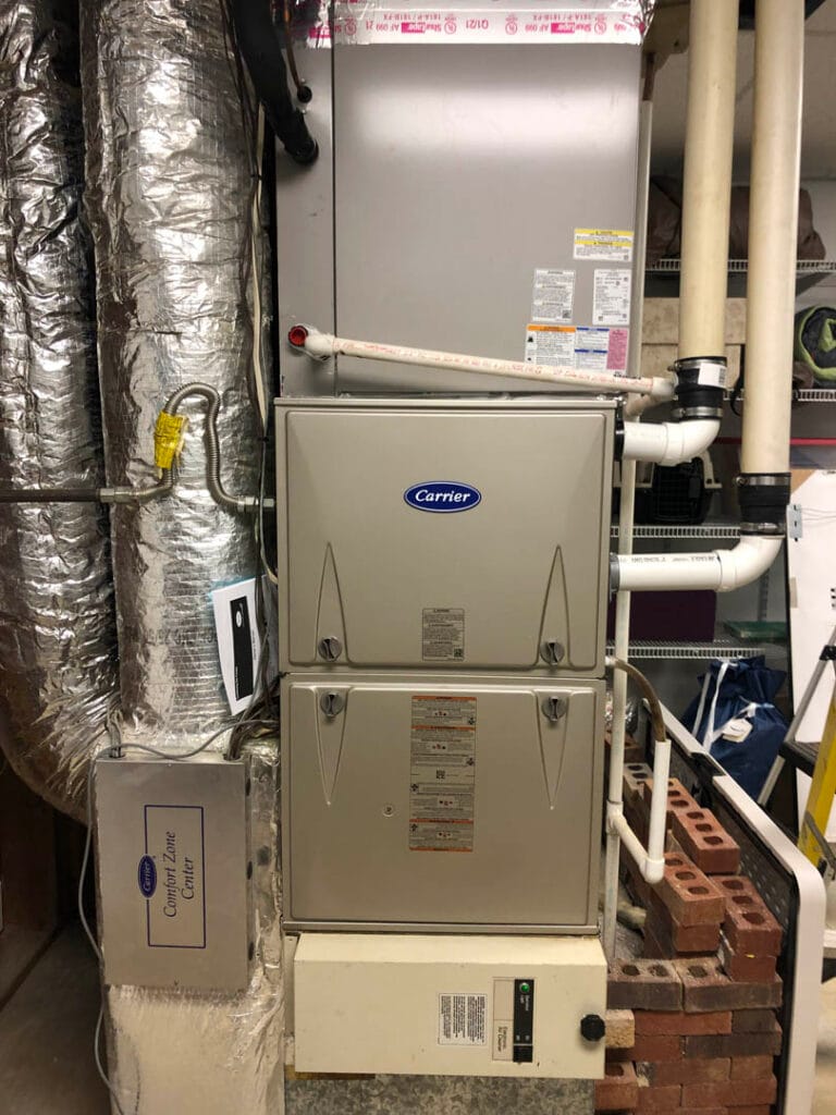 AC Repair & Maintenance 10 Indoor HVAC system with Carrier brand labeling, expertly installed alongside insulated ducts and pipes, showcasing a seamless AC installation.