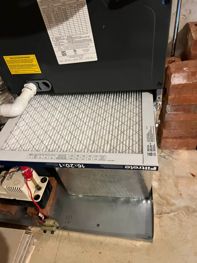 Atlanta Heating Services 5 An air filter is expertly installed in a furnace unit, seamlessly integrated into the brick enclosure as part of an efficient HVAC installation.
