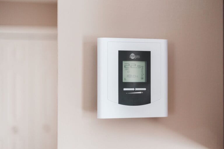 This wall-mounted digital thermostat, a dynamic content widget, displays precise temperatures of 22.5°C and 16.0°C, ensuring optimal comfort in your home environment.